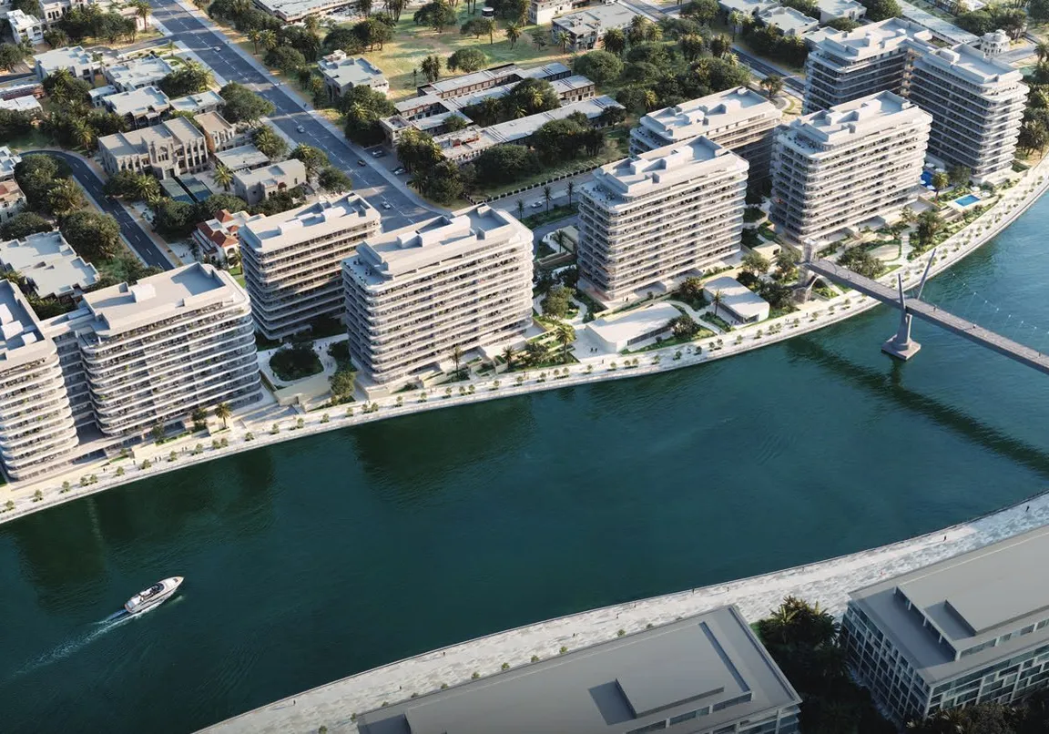 Aerial view of seven buildings along the canal and footbridge